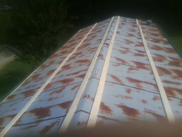 Rusted metal roof panels with new wood purlins before replacement — Storm Damage Roof Repair in Smoaks by Roofing Brothers