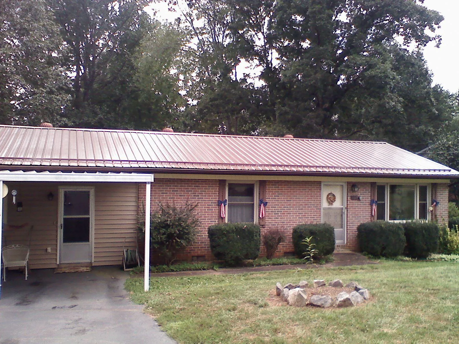 Bronze metal roof and carport on a brick ranch home — Roof Repair work by our crew in Smoaks